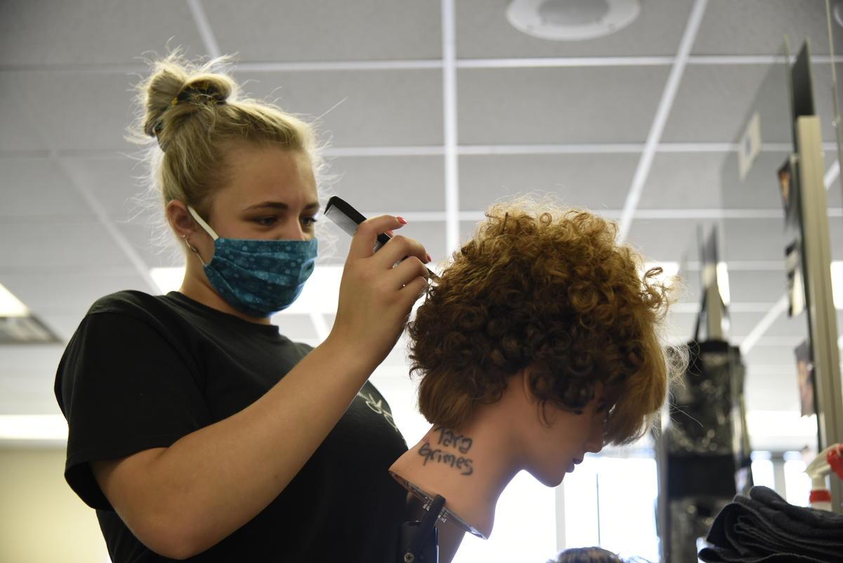 A cosmetology student at the AK Smith Career Center in Michigan City works on a mannequin for a class assignment.