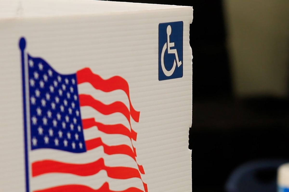 A voter screen is decorated with an American flag and a handicap logo.