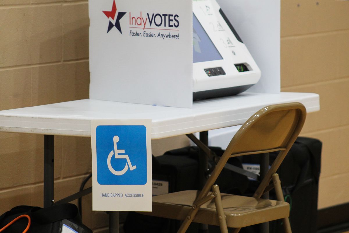 A voting booth with a blue accessibility sign posted to the table.