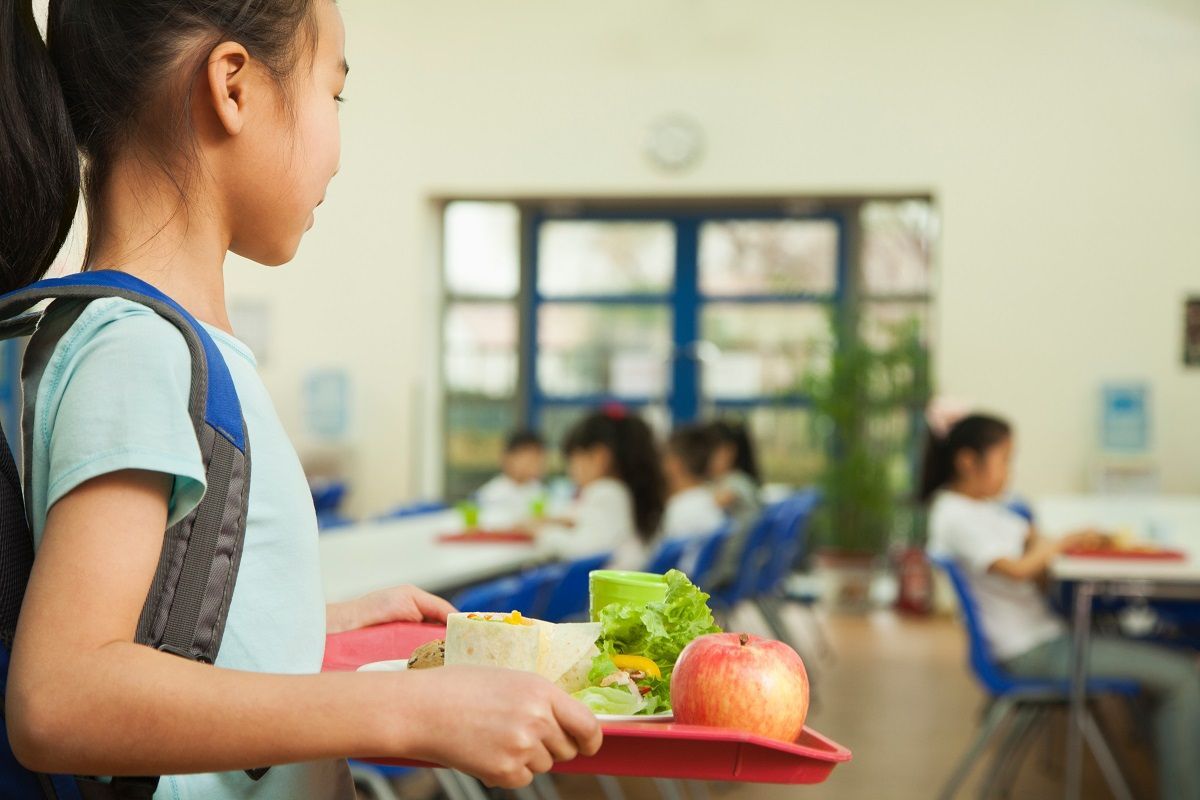 Girl holding tray with school lunch