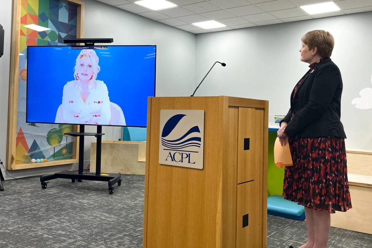 Allen County Public Library executive director Susan Baier stands by as a video from Dolly Parton explaining the mission of the Imagination Library plays.