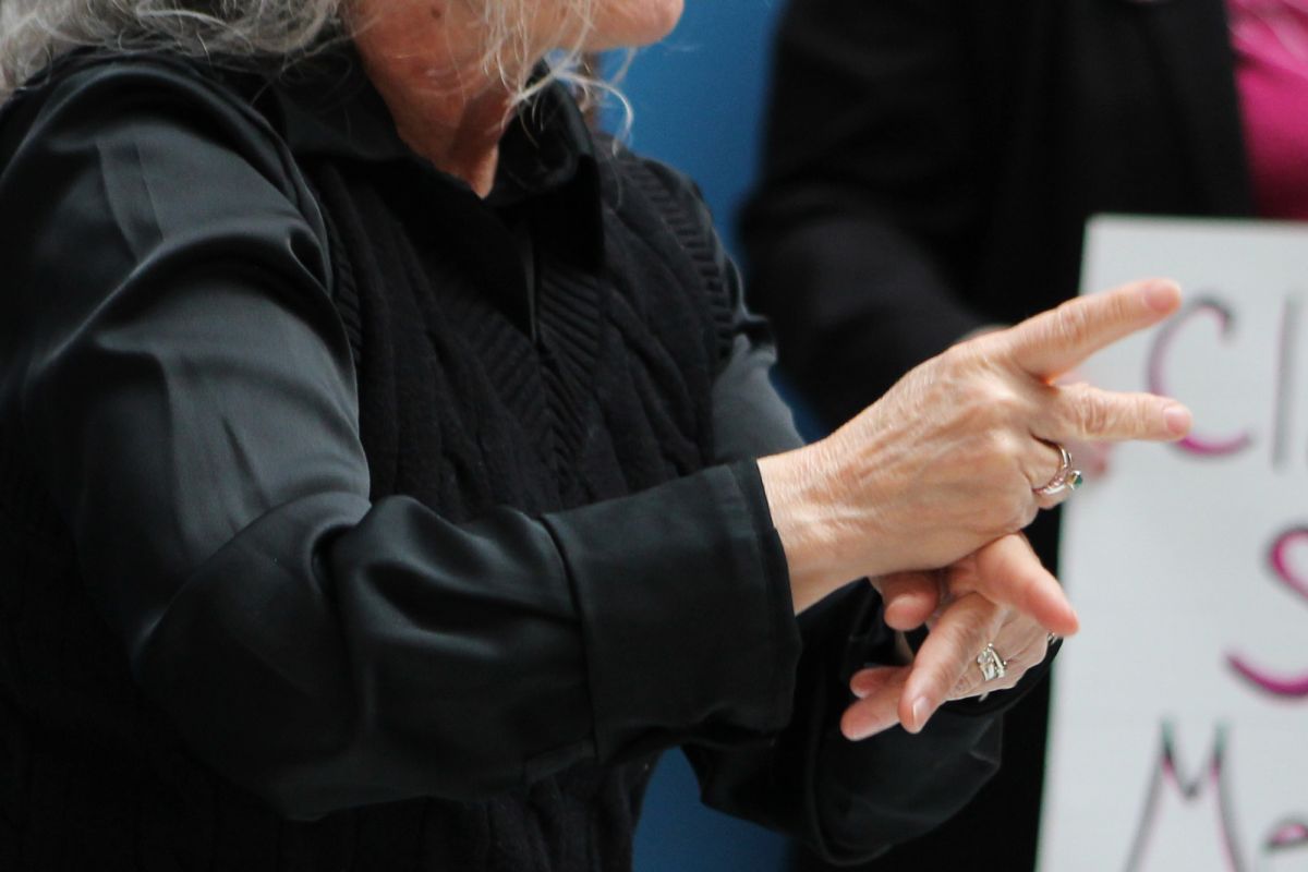 An ASL interpreter signing at a rally at the Statehouse. 