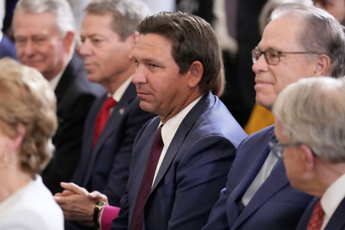 Florida Gov. Ron DeSantis, center, and Indiana Gov. Mike Braun listen as President Donald Trump speaks at an education event and executive order signing in the East Room of the White House in Washington, Thursday, March 20, 2025.