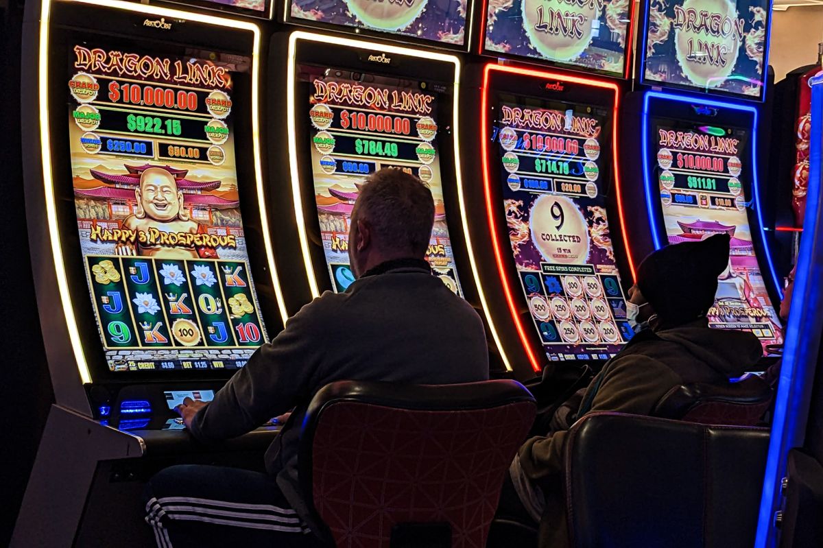 A person sits at a slot machine.