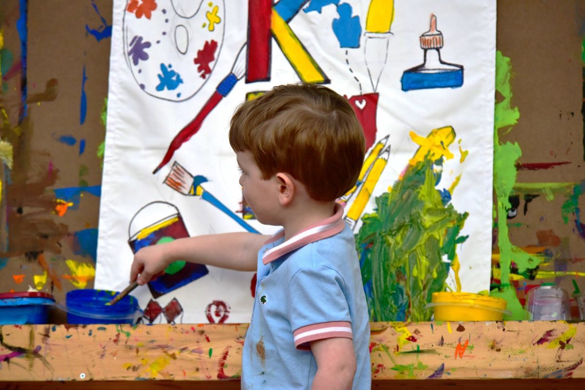 child paints a canvas