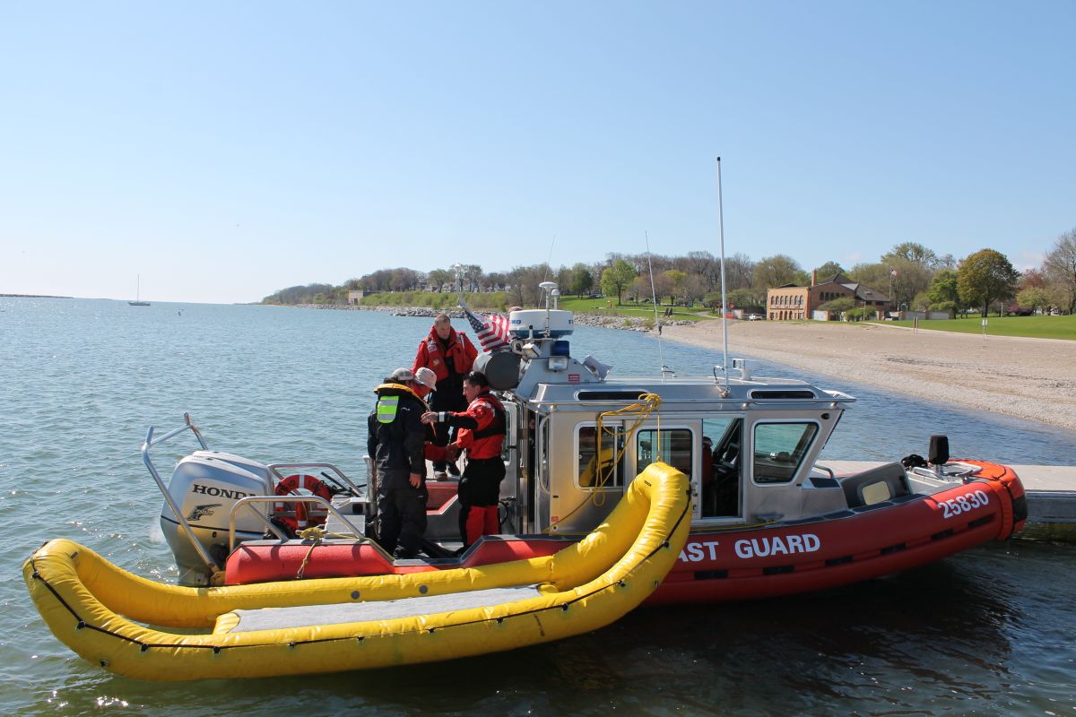 A boat crew from Coast Guard Station Milwaukee rescues three men from Lake Michigan after their boat capsized near South Shore Marina in Milwaukee, 2015.