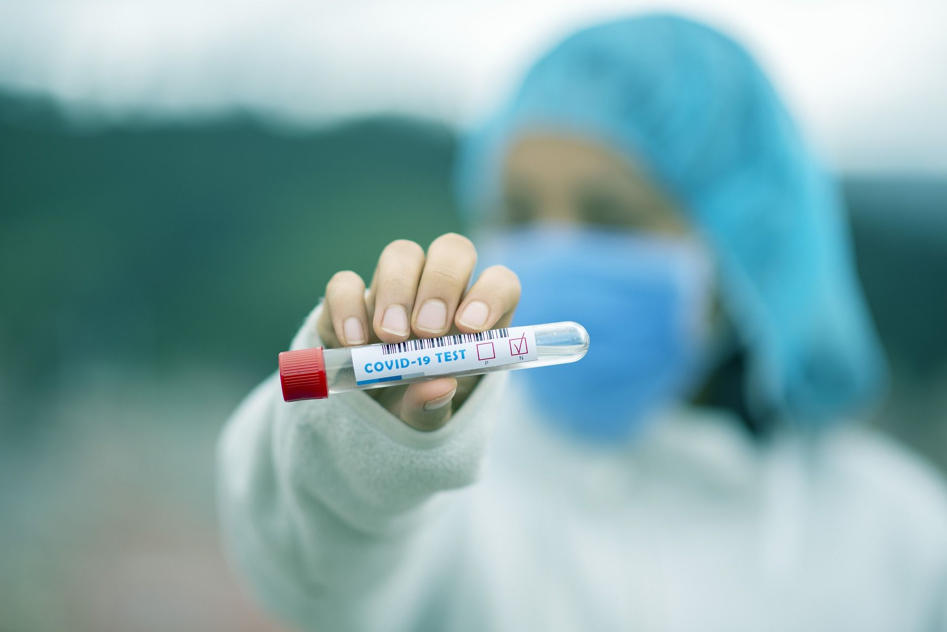 A medical professional/doctor/nurse holds a COVID-19 test tube.