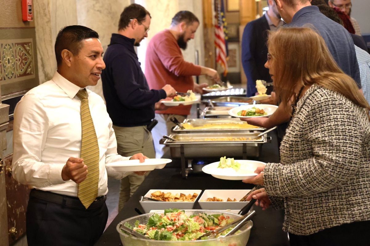 Diego Morales, left, goes through the line at a staff Thanksgiving meal costing $3,000. 