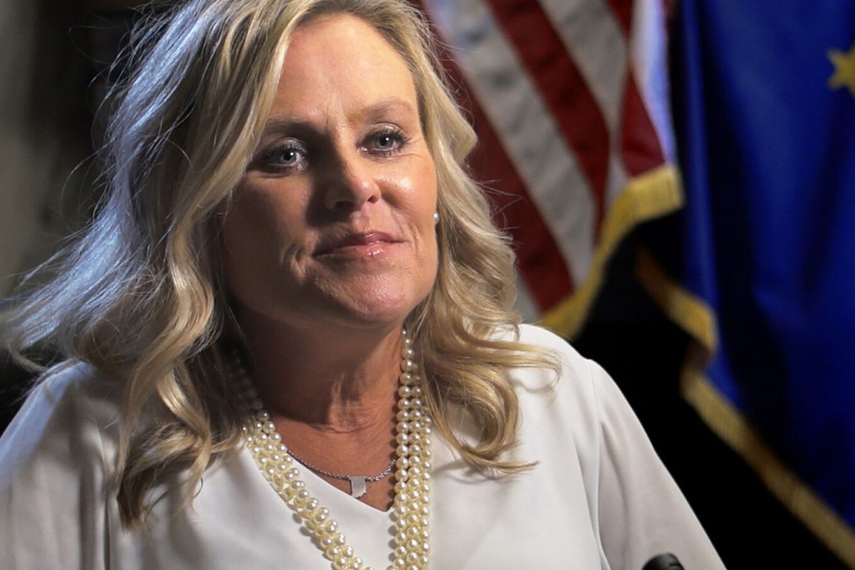 Jennifer McCormick sits for an interview with an American flag and Indiana flag in the background. 