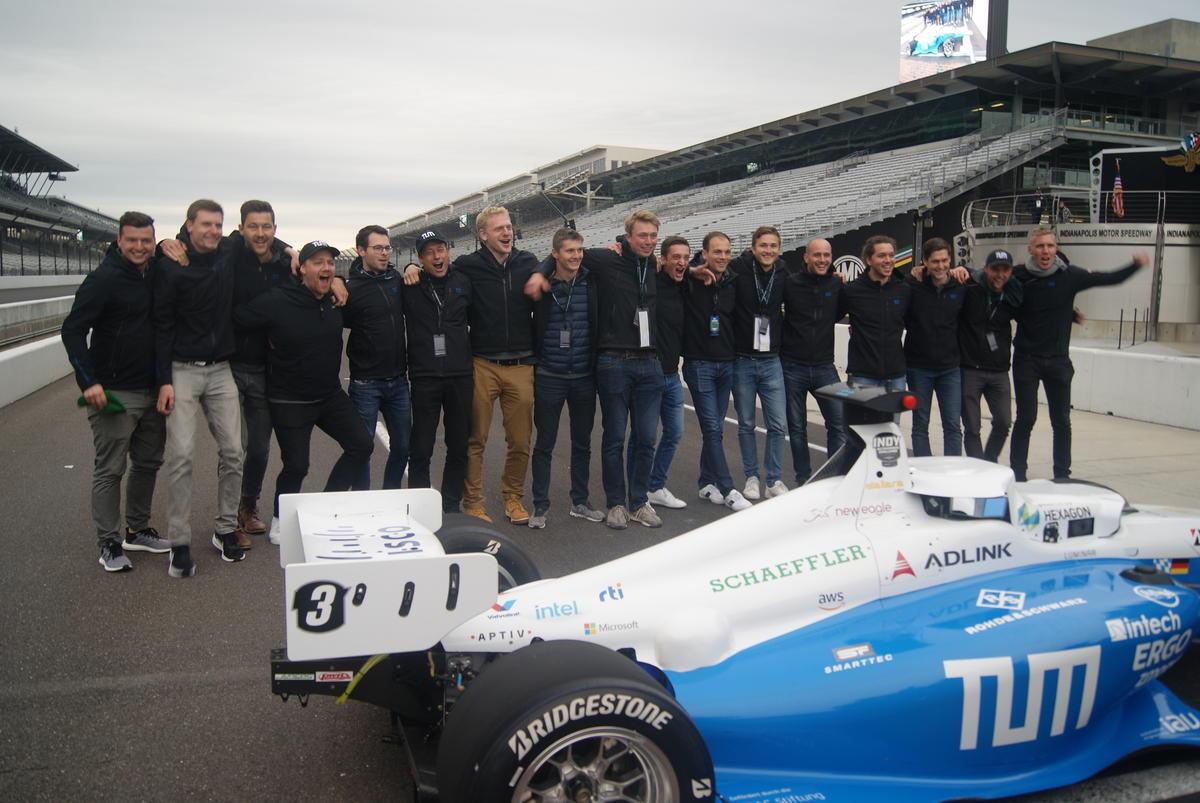 The TUM Autonomous Motorsport team celebrates along the yard of bricks at the Indianapolis Motor Speedway after winning the Indy Autonomous challenge.