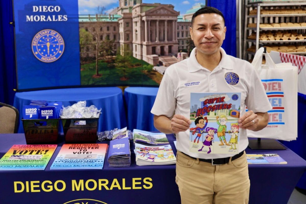 Secretary of State Diego Morales holds a Hoosier-themed coloring book at one of his Indiana State Fair booths