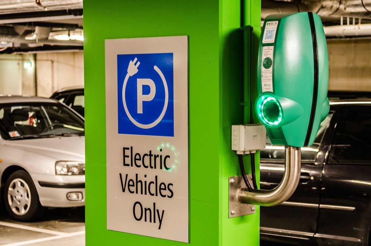 A charging station for electric vehicles inside a parking garage with a sign that reads "electric vehicles only."