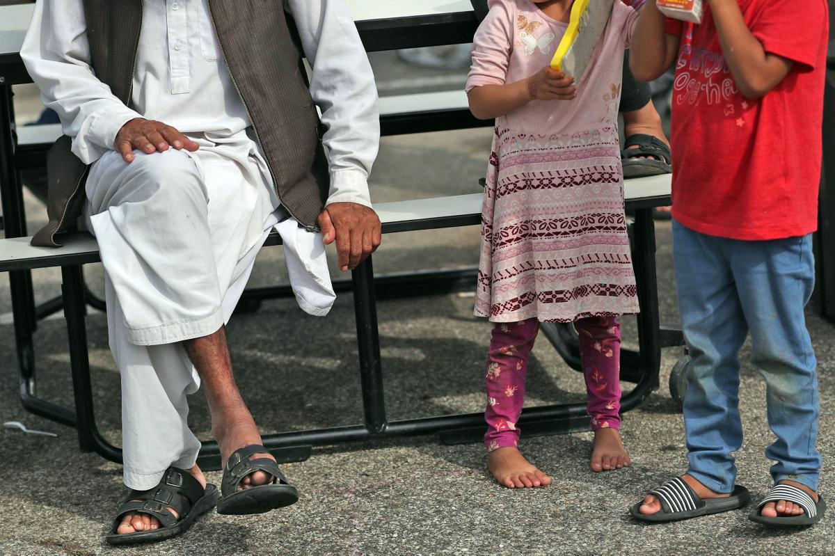 Afghan evacuees sitting around