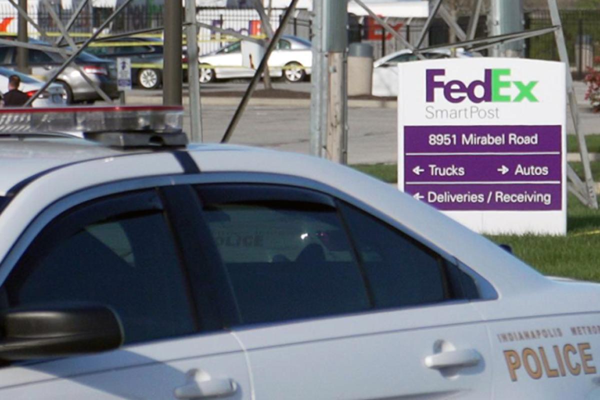 An Indianapolis Metropolitan Police Department vehicle restricts access to the FedEx facility where eight people were shot and killed by a former employee on April 15, 2021.