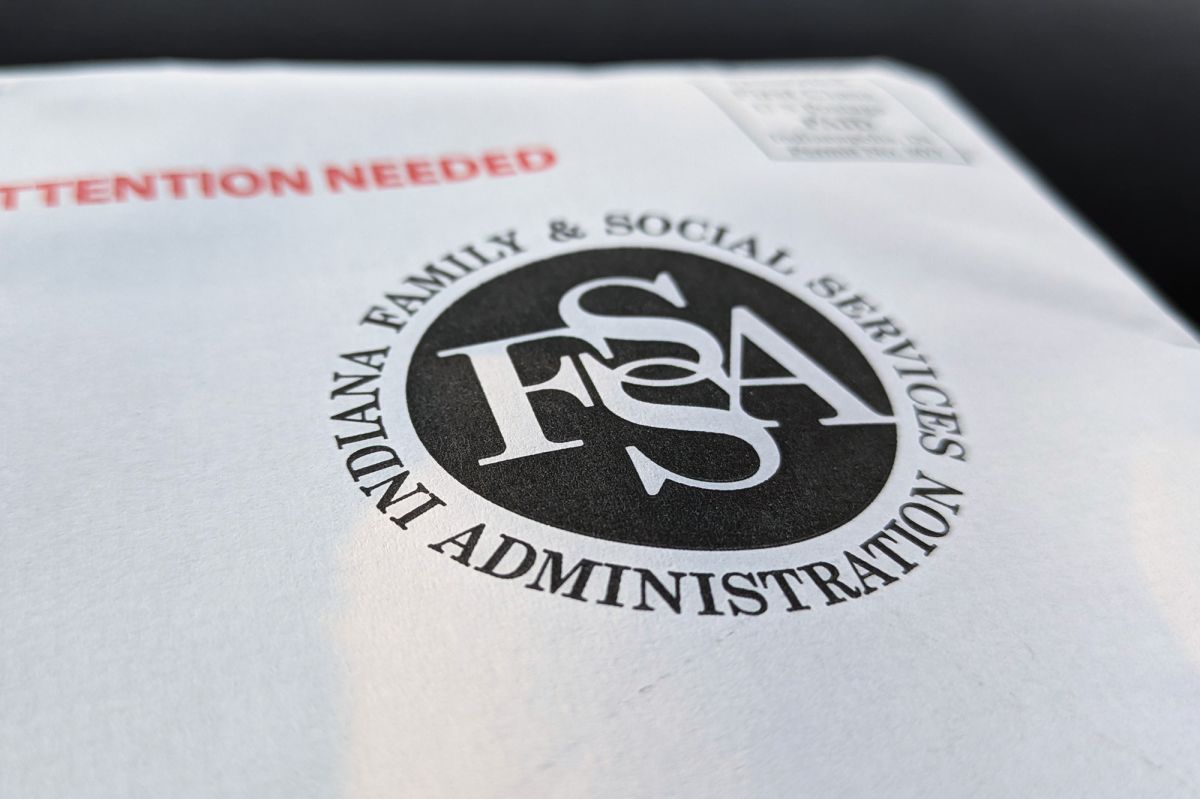 A white envelope with a black Indiana Family and Social Services Administration logo printed on it with the words "Attention needed" printed in bright red. 