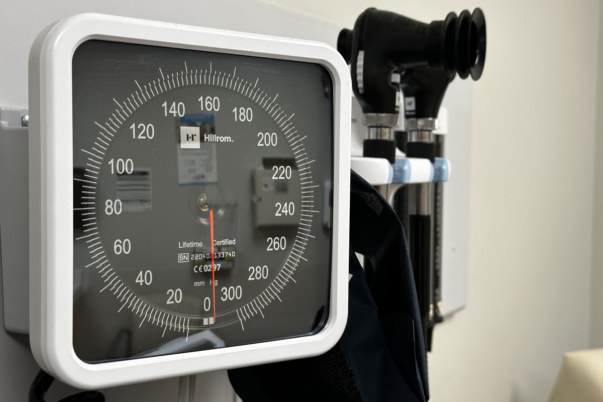 A sphygmomanometer, for reading blood pressure, affixed to a wall in a doctor's office. 