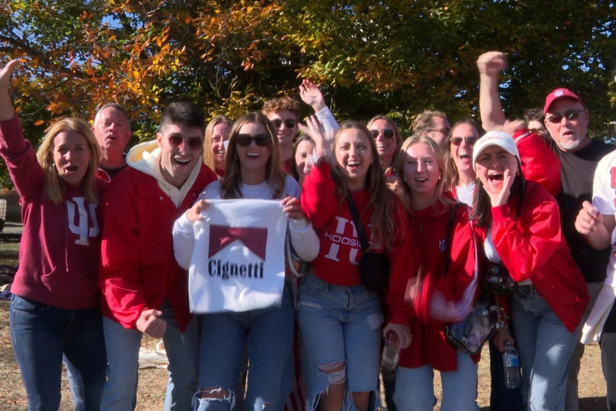 IU fans cheer together, waving a Cignetti towel