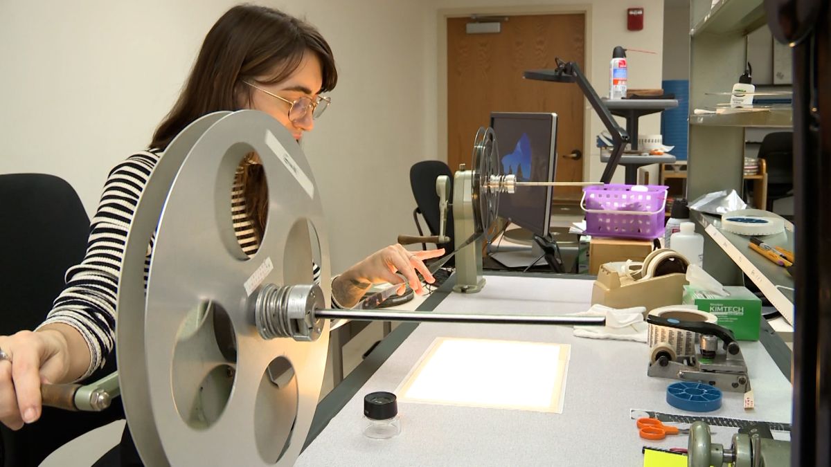 woman working with 16mm film at the IU Moving Image Archive
