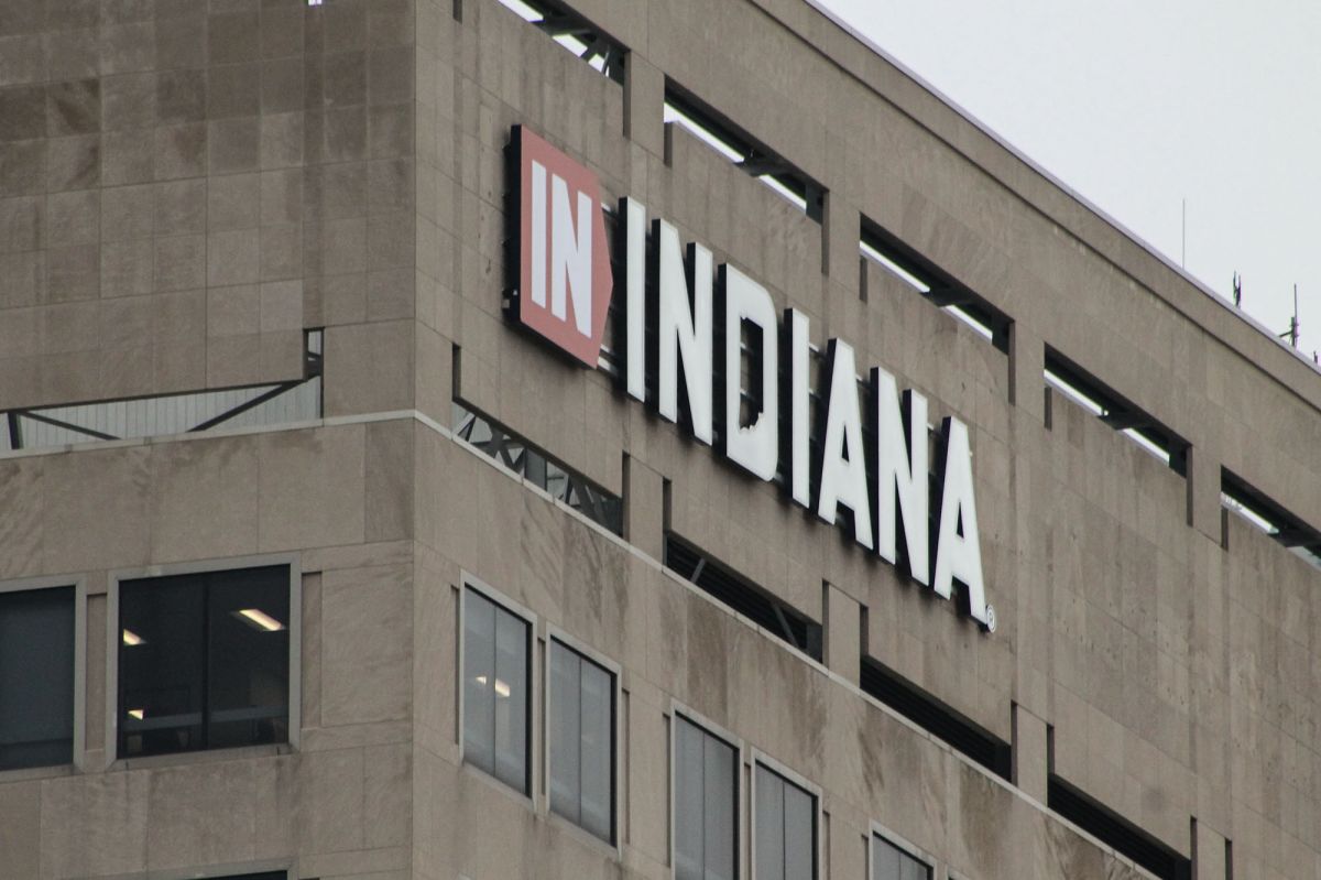 A tall brown building has a sign that reads "IN INDIANA" in the top left corner of it. 