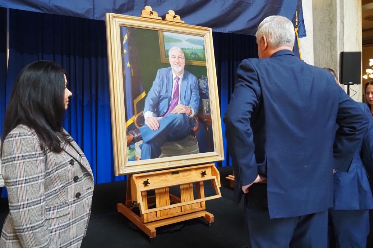 Gov. Eric Holcomb and First Lady Janet Holcomb view the newest gubernatorial portrait, painted by artist Russell Recchion, on Friday, Dec. 13, 2024, following an unveiling ceremony at the Indiana Statehouse.