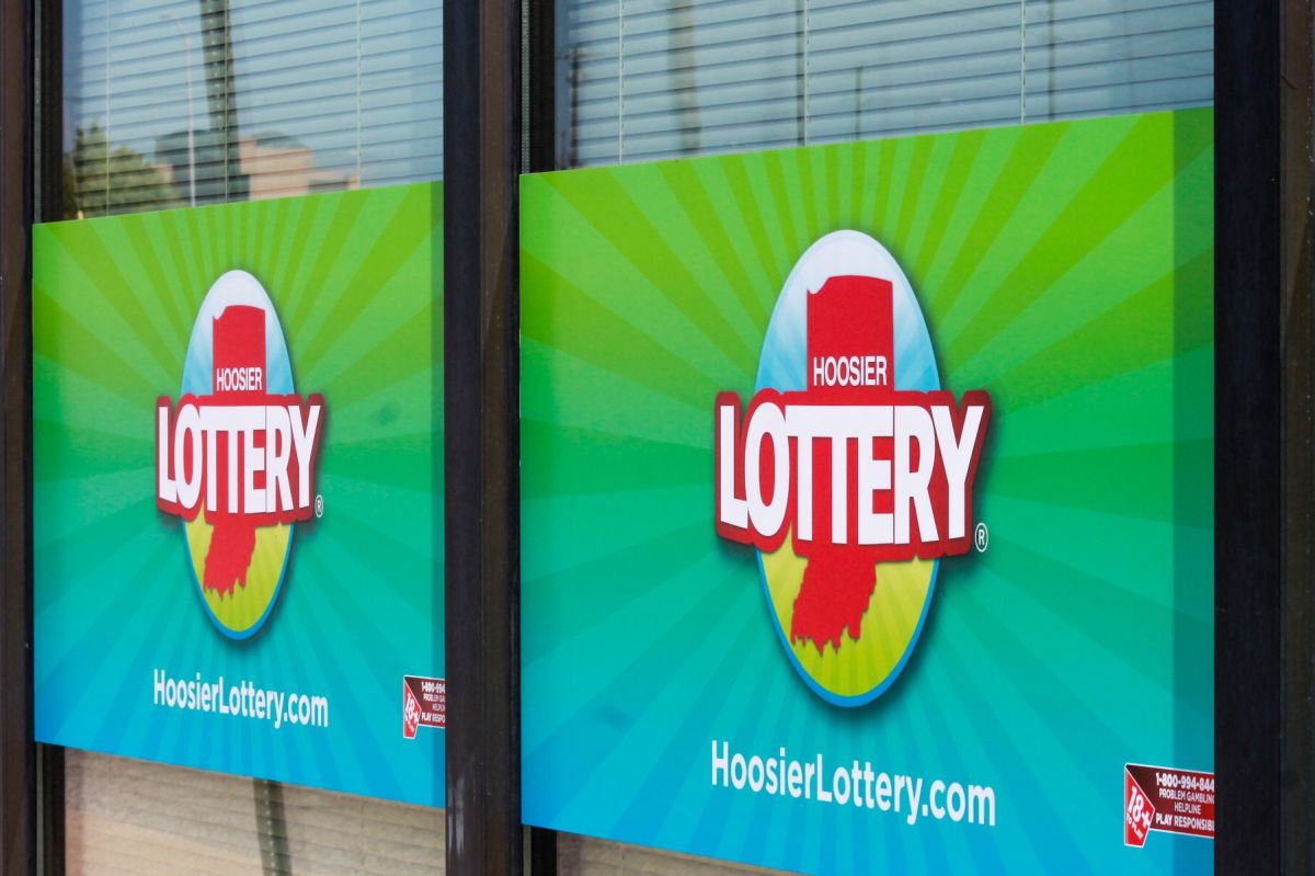 Two signs hanging in a window show the logo for the Hoosier Lottery.