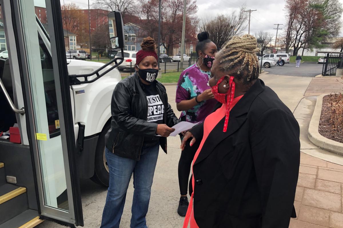 Harriett Rankin, a member of Black Lives Matter Louisville, helps residents board a van to get their second dose of the COVID-19 vaccine.
