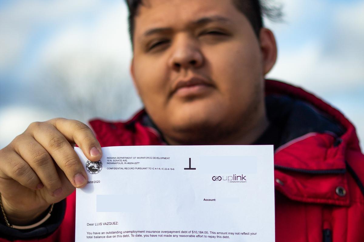 Luis Vazquez holds a letter from the Department of Workforce Development saying he owes back over $10,000 in unemployment benefits.
