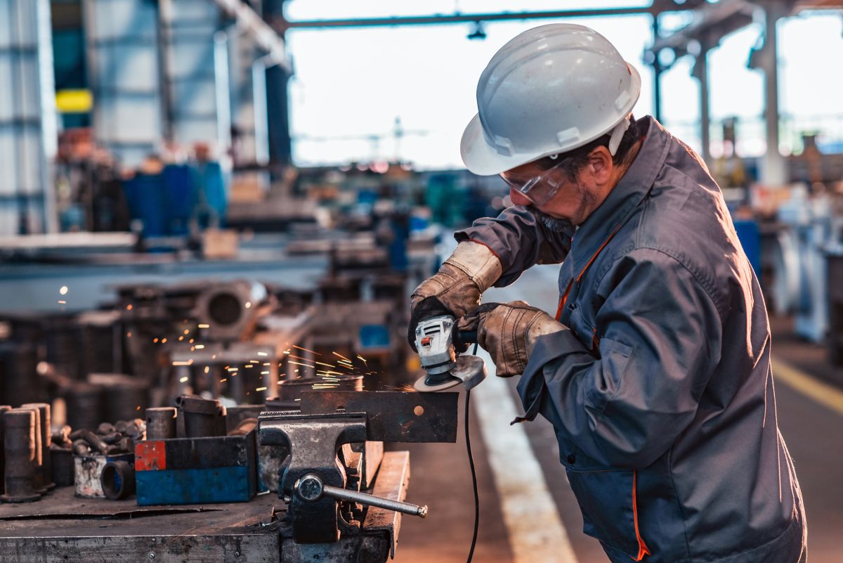 industrial worker grinding metal part