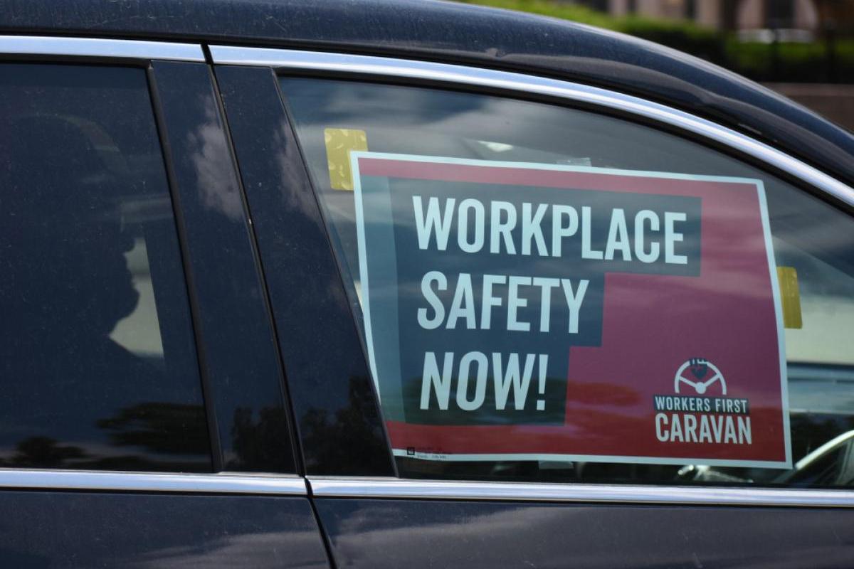 A sign in a car caravan at a labor rally in 2019 reads "Workplace Safety Now!"