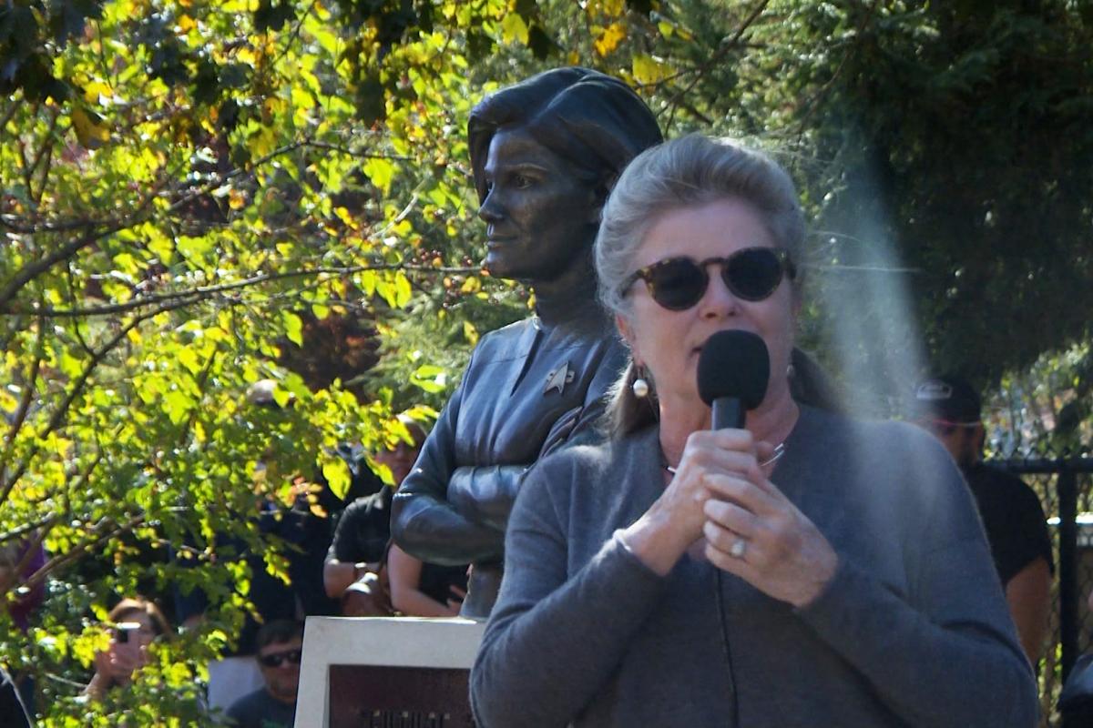 Actress Kate Mulgrew speaks in front of the Captain Kathryn Janeway statue on the B-Line Trail Sunday.