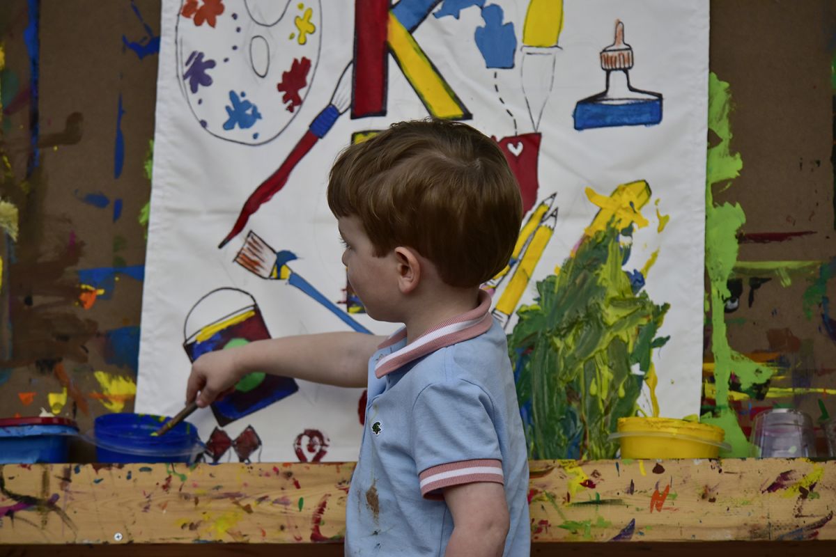 child paints a canvas