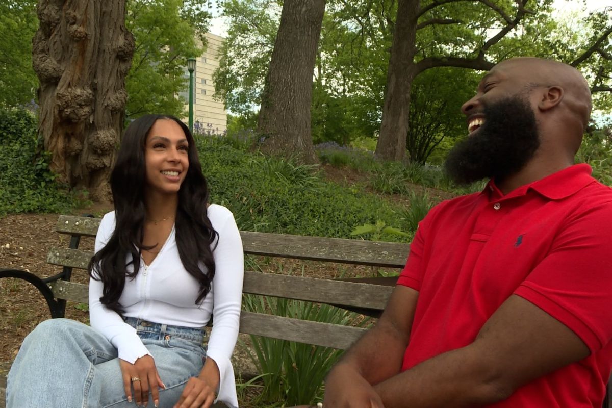 Liv Clements and Reggie Johnson sit on a bench 