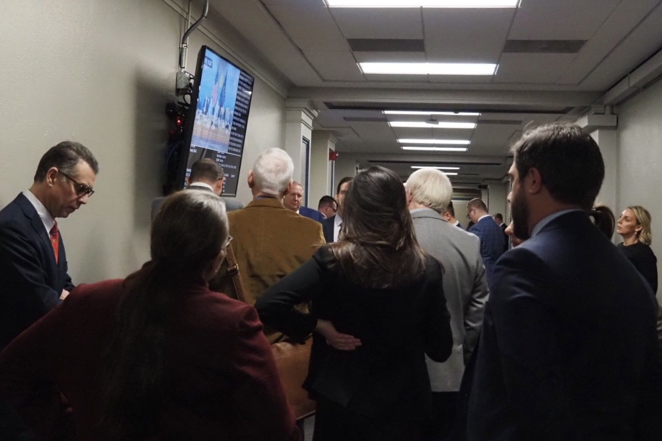 Lobbyists and other stakeholders gather around a screen to watch live committee proceedings on Tuesday, Feb. 4, 2025. 