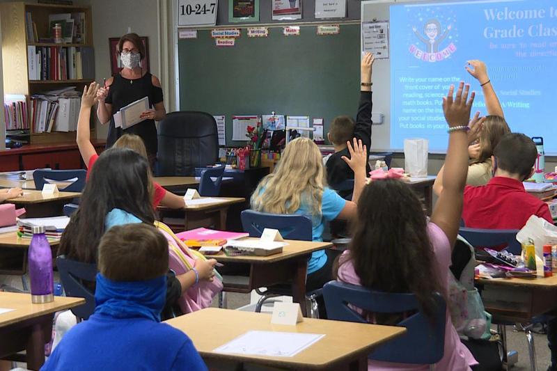 A classroom in a Logansport school, where the teacher is wearing a mask.