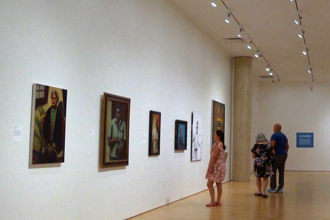 Visitors view Mellencamp’s paintings at the Eskenazi exhibit.