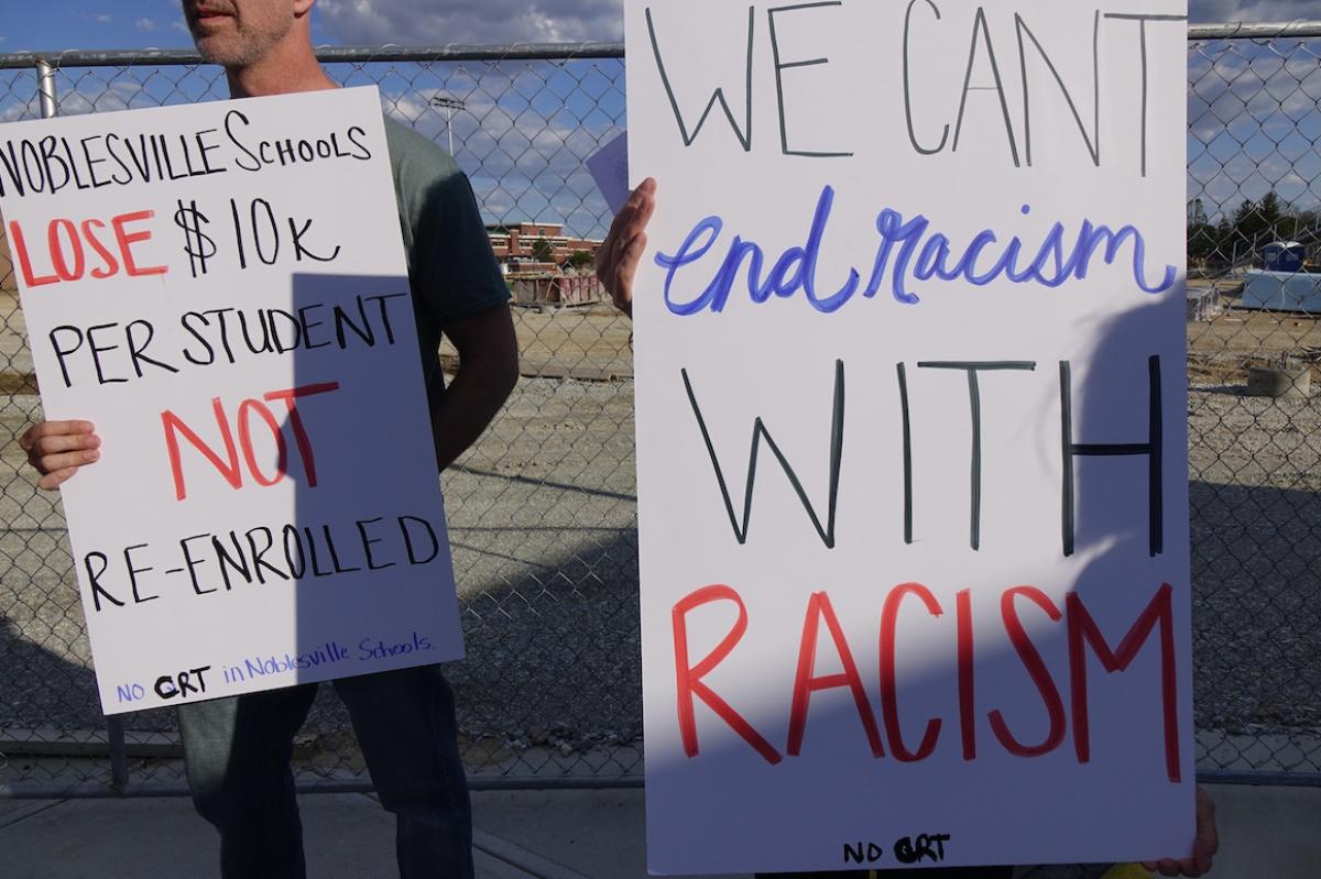 Parents hold signs protesting the teaching of racism at Noblesville Schools outside the district community center on Thursday, May 13, 2021.