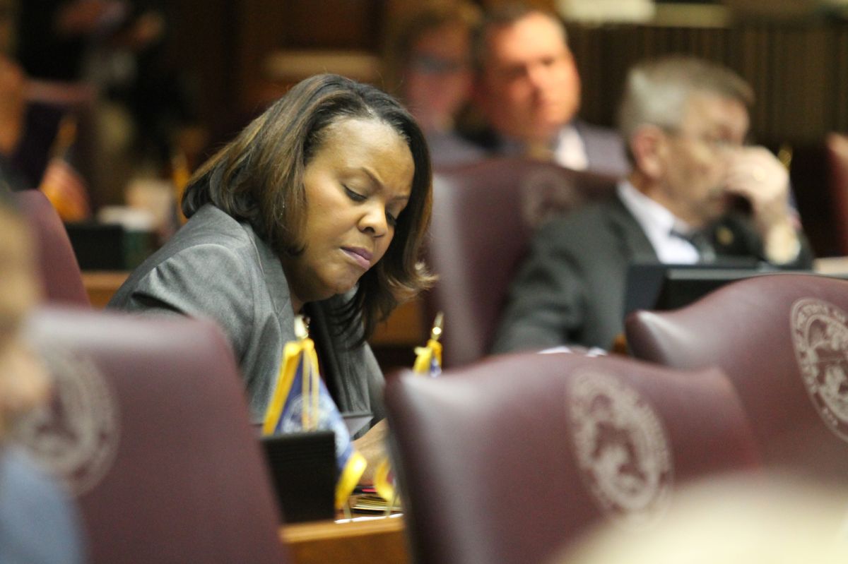 Representative Robin Shackleford sitting at her desk on the house floor. Shackleford is a Black woman, with shoulder-length dark brown hair.