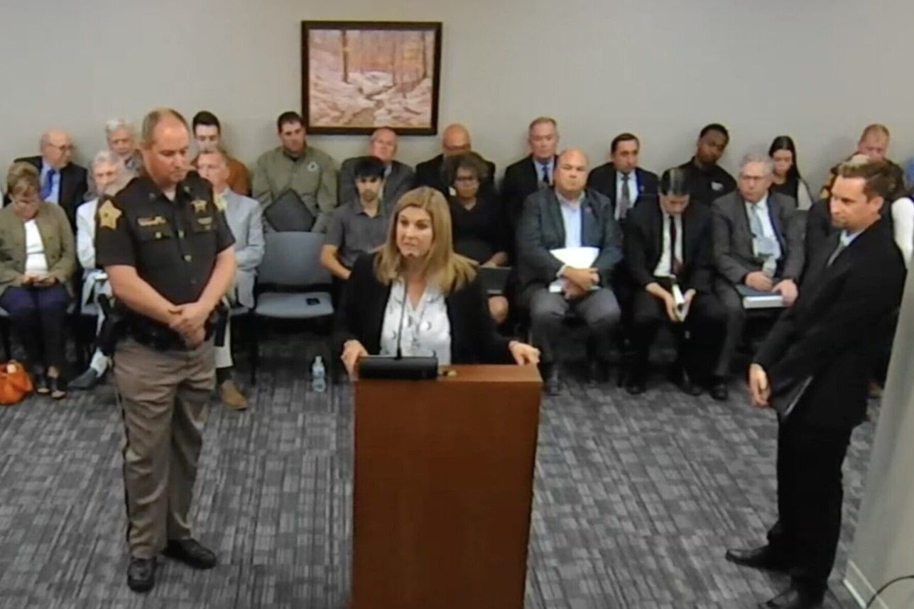 Vanderburgh County Sheriff Noah Robinson (left) watches as County Council President Jill Hahn testifies to lawmakers