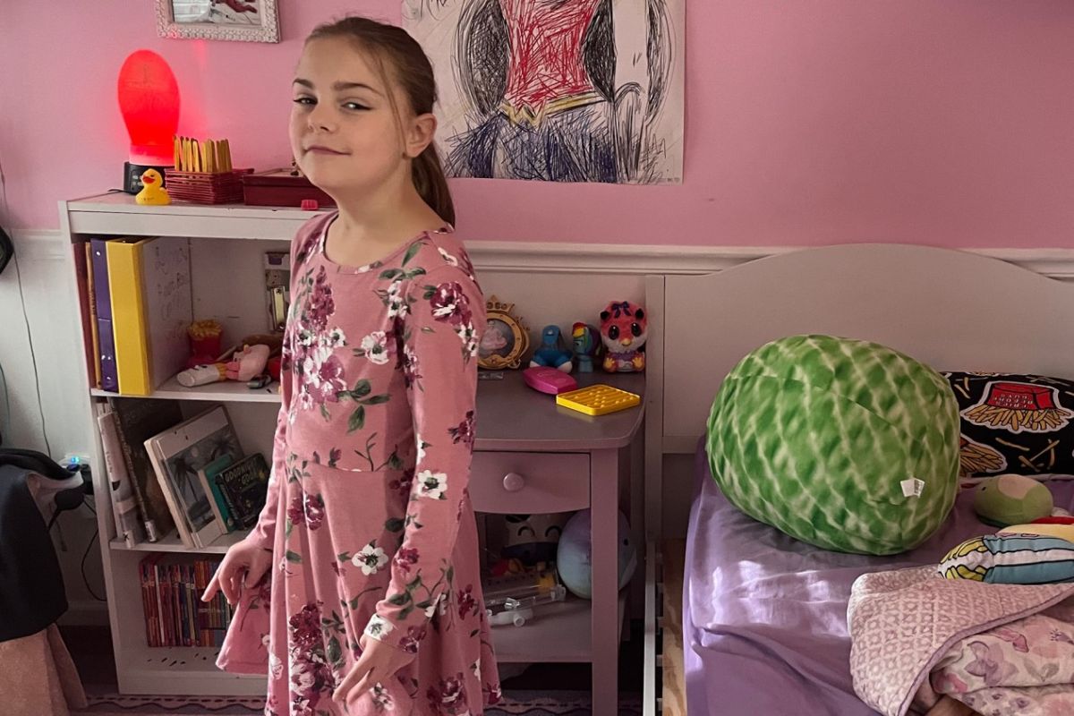 Lena, a fourth grader with multiple chronic health conditions, stands in the bedroom of her northwestern Indiana home on Tuesday, Sept. 26, 2023.