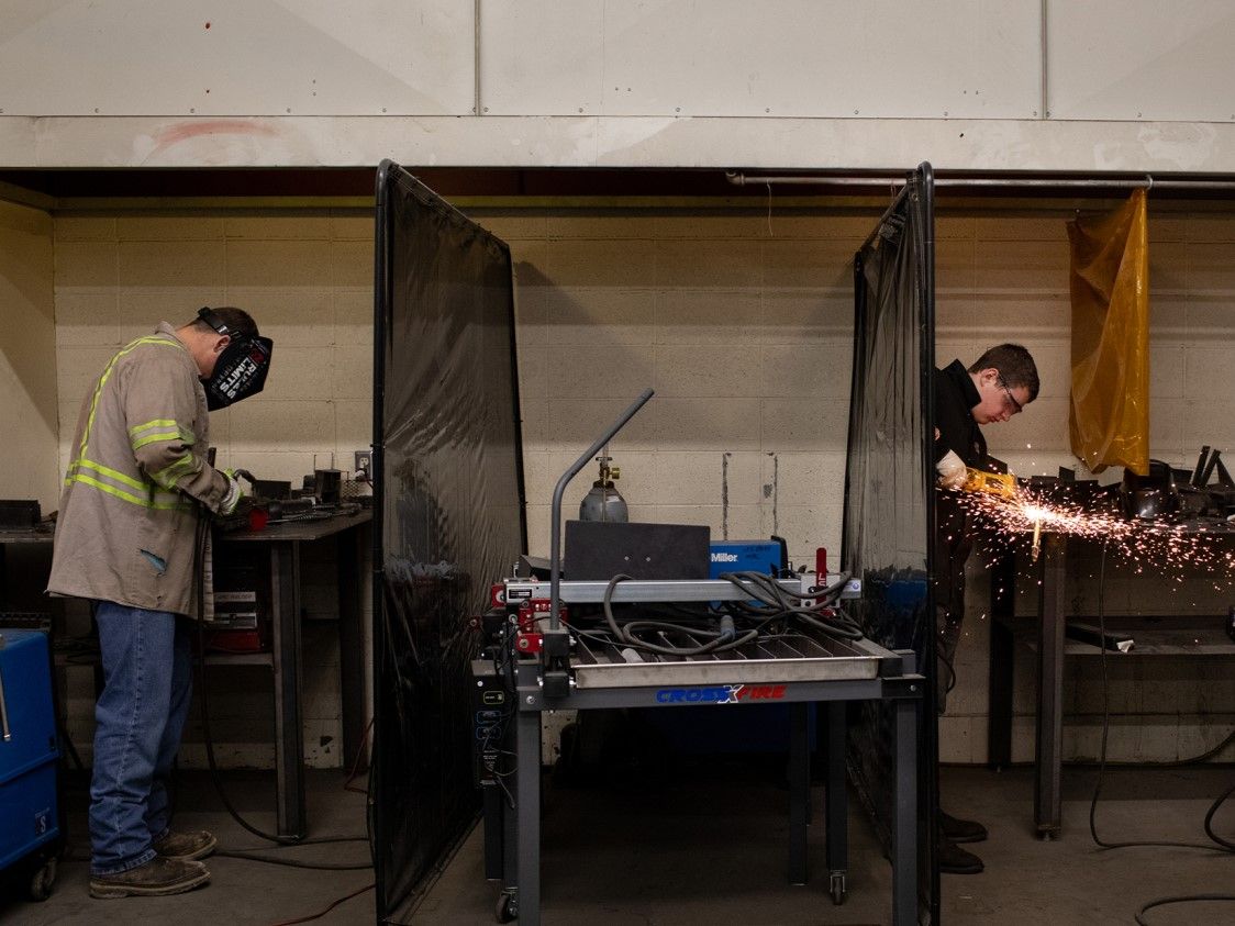 students are welding with helmets on