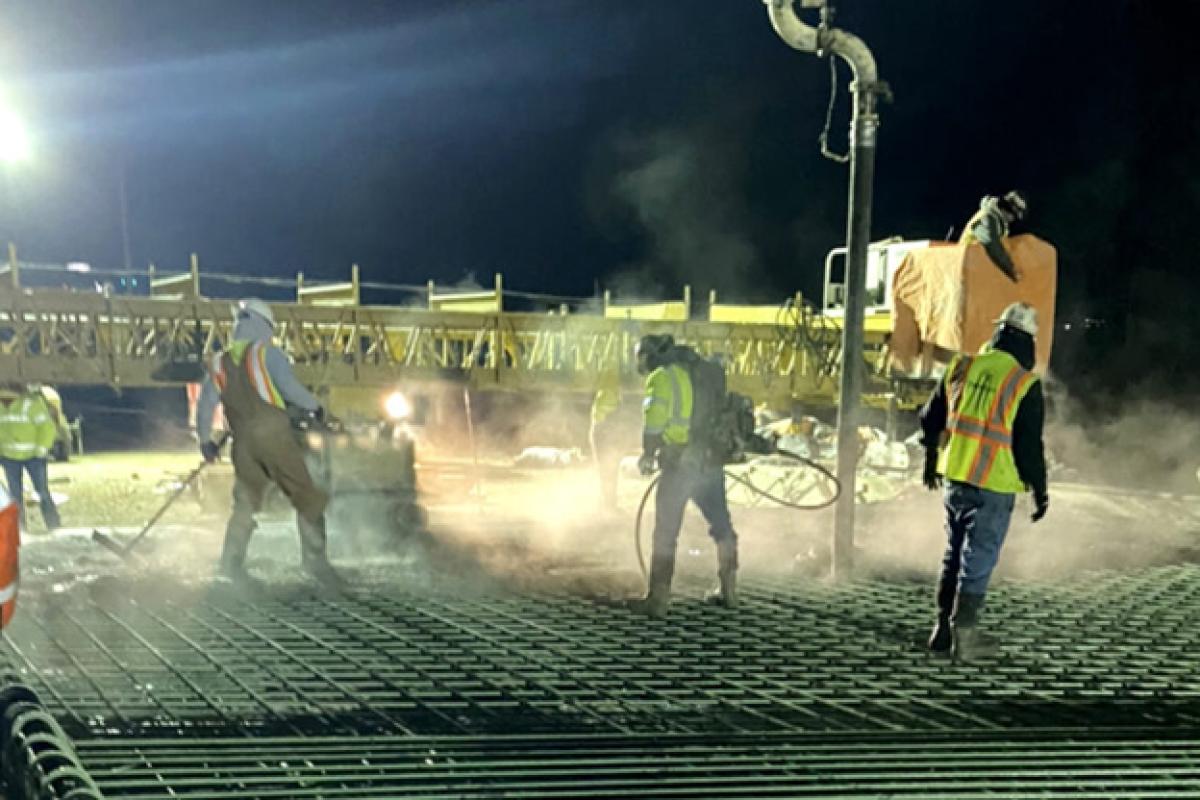 Workers pour concrete for the new ramp over Bluff Creek bridge.