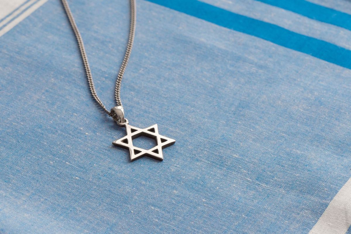 Star of David necklace on white-blue fabric