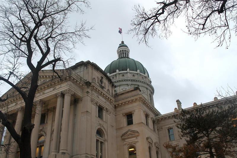 Indiana statehouse in winter with bare trees and gray sky