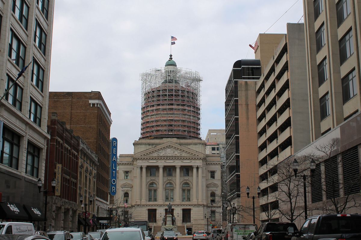 The northwestern exterior of the Indiana Statehouse with scaffolding surrounding the dome.