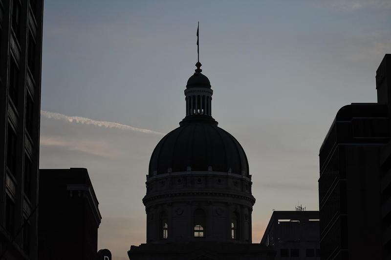 The Indiana Statehouse silhouetted at night.