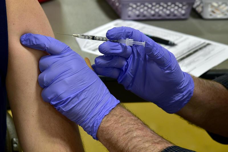 A photo of someone administering a vaccine.