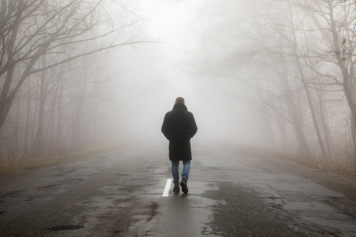 Man walking away in foggy rain