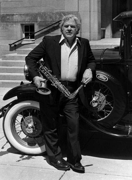Al Cobine standing with saxophone in front of vintage car