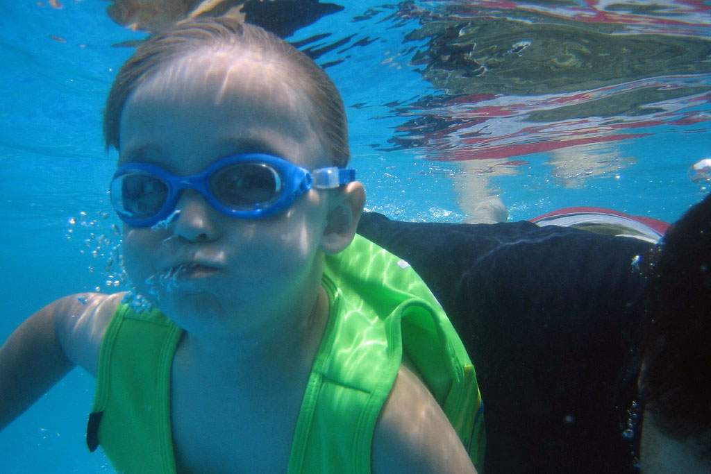 child underwater holding breath