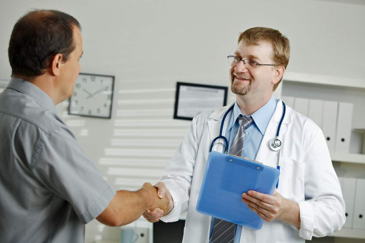 doctor with patient in waiting room shaking hands